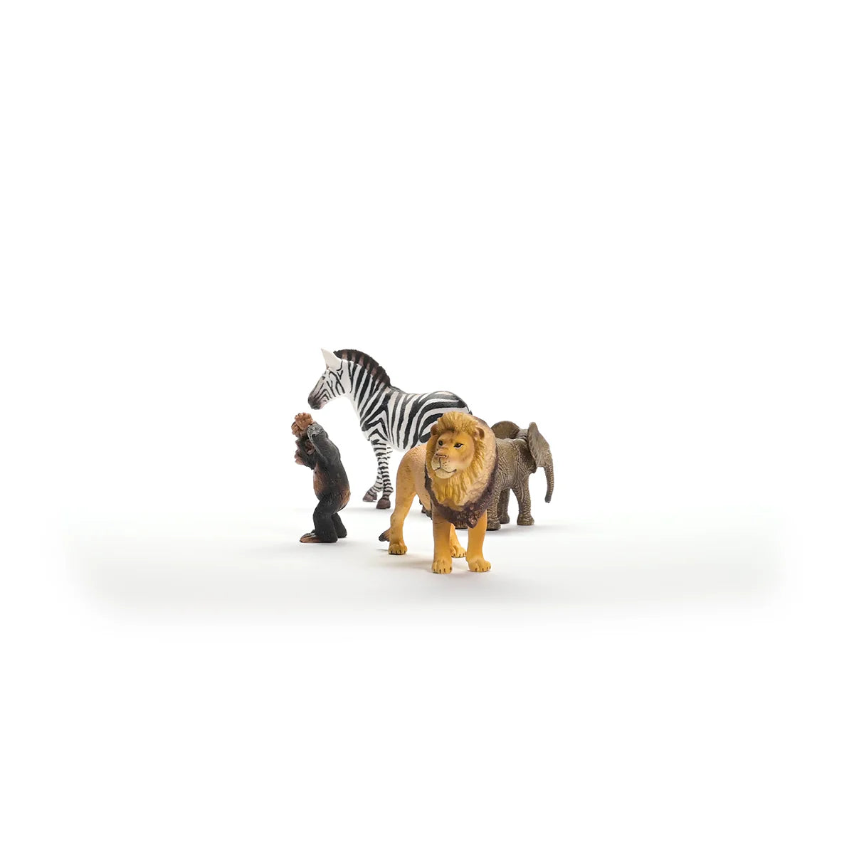 Toy figures of a lion, zebra, and elephant on a white background