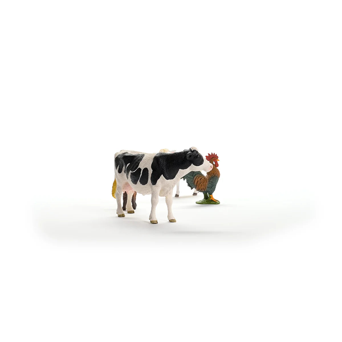 Small figurine of a cow and rooster on a white background