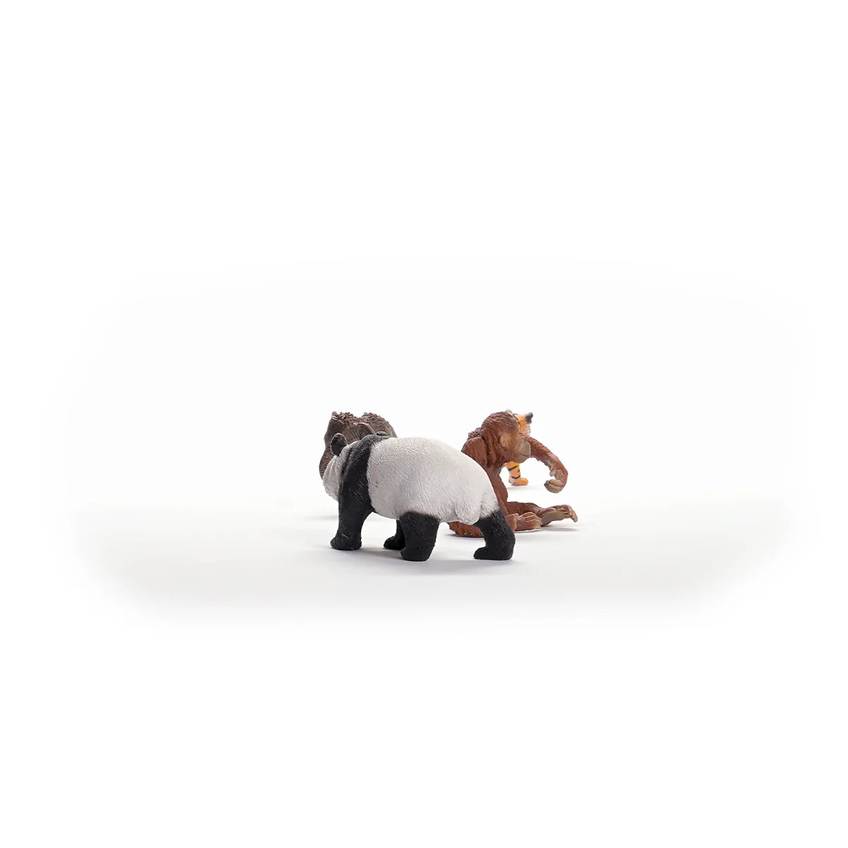 Two toy figures of a panda and a monkey on a white background