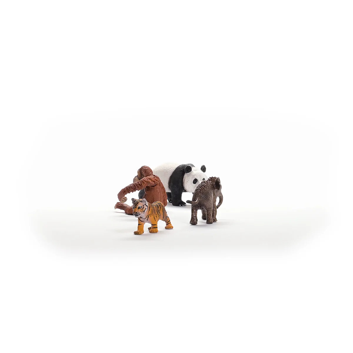 Toy figures of a panda, tiger, and monkey on a white background