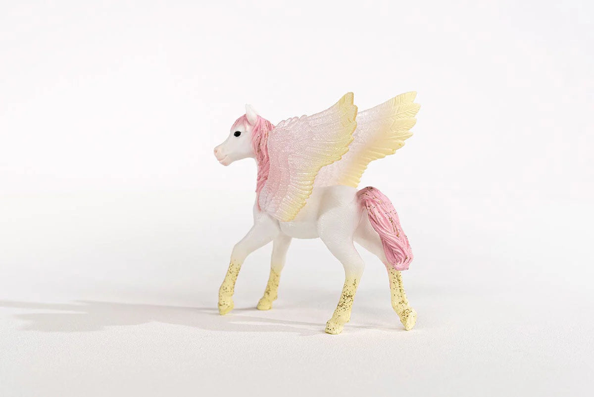 Toy pegasus with pink and yellow wings on a white background