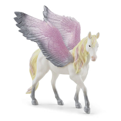 Unicorn figurine with purple and pink wings on a white background