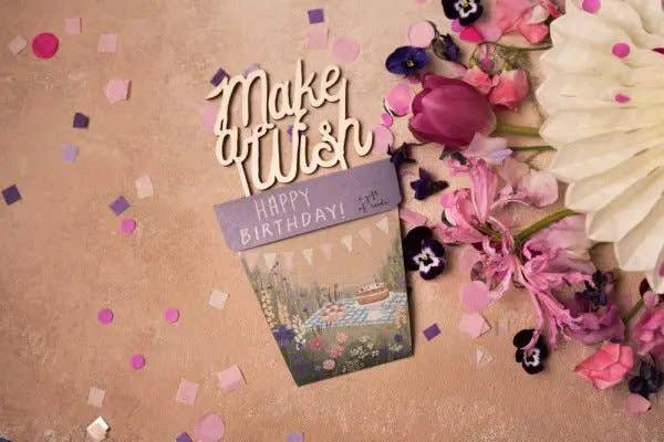 Birthday card with decorative text and flowers on a brown background