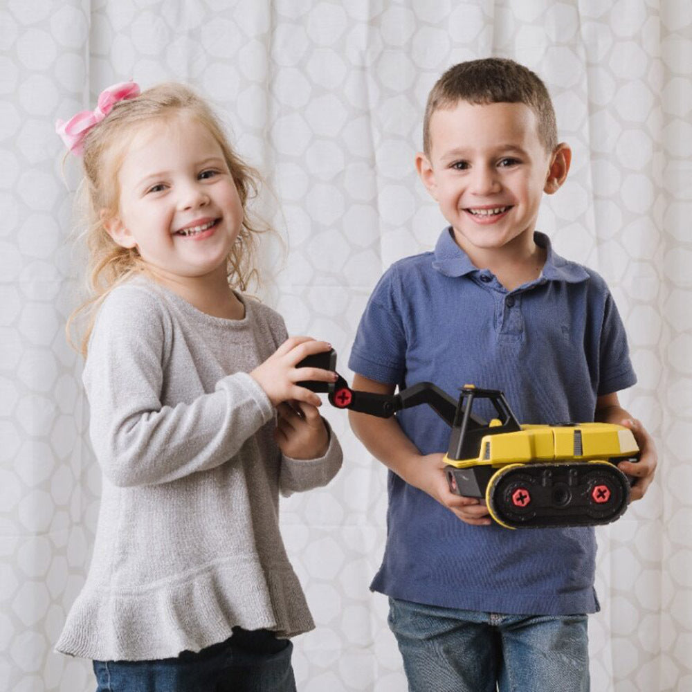 Two children holding toy construction vehicles against a light background