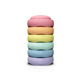 A stack of six textured, donut-shaped bath or body soaps in pastel rainbow colors, including pink, orange, yellow, mint green, light blue, and lavender, set against a solid white background.