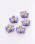 Purple flower-shaped objects with yellow centers on a white background
