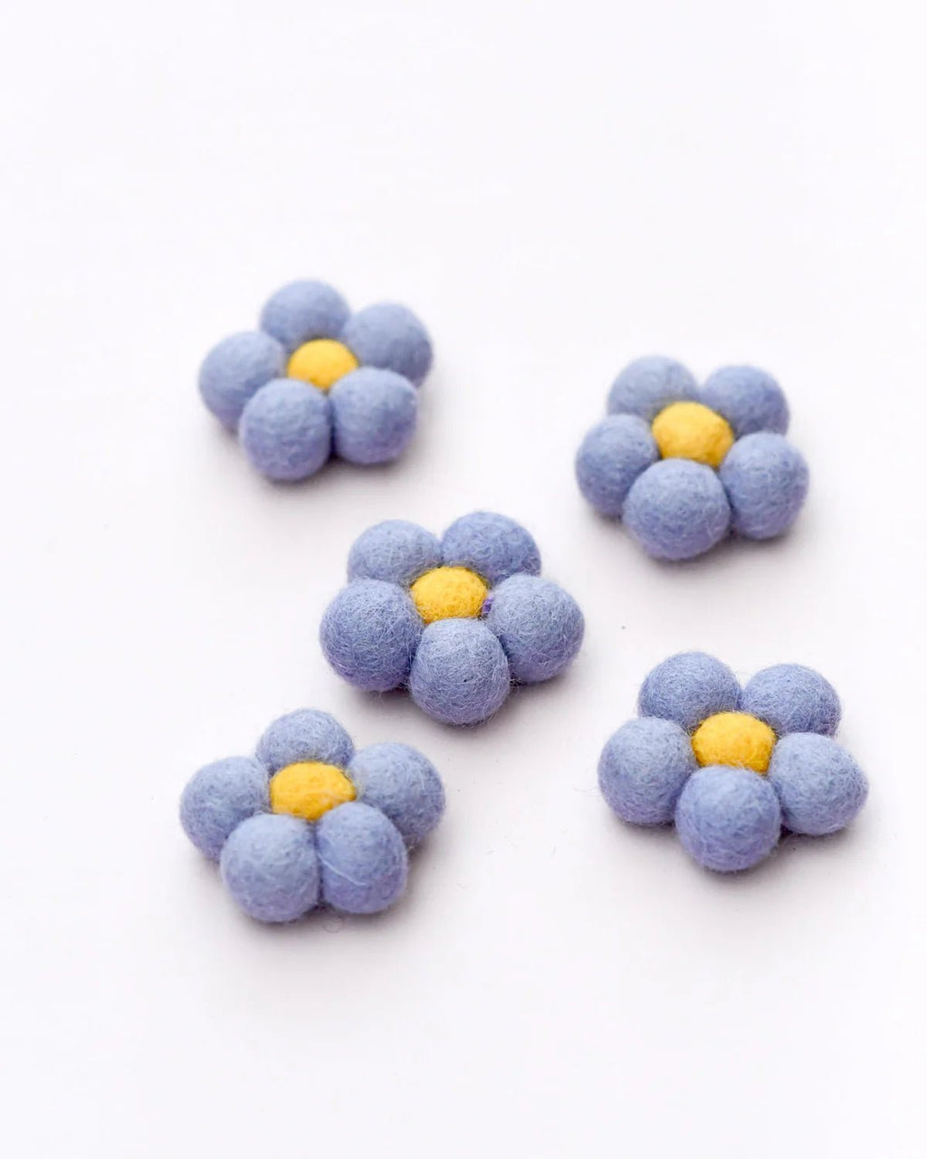 Set of five blue flower-shaped objects with yellow centers on a white background