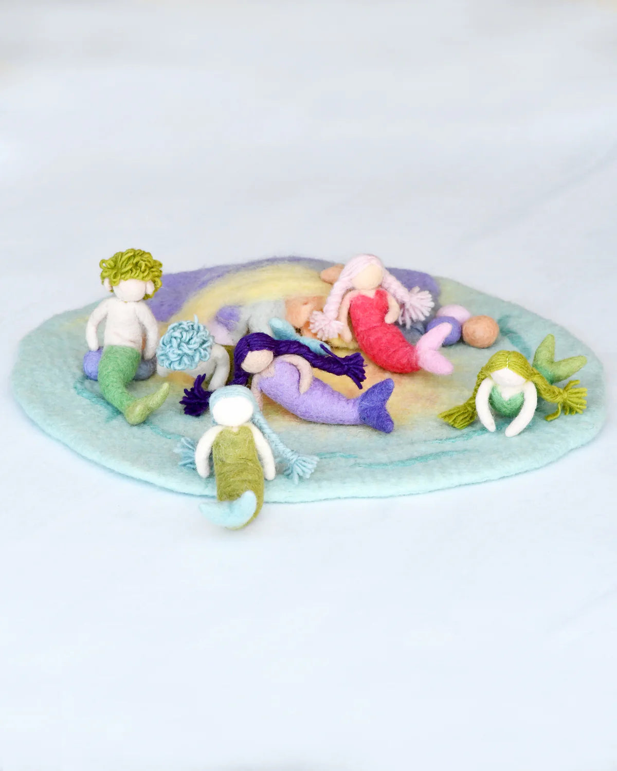 Set of mermaid-themed toys on a circular mat with a white background