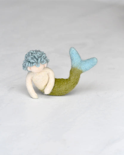 Mermaid toy with a blue top and green tail on a light gray background