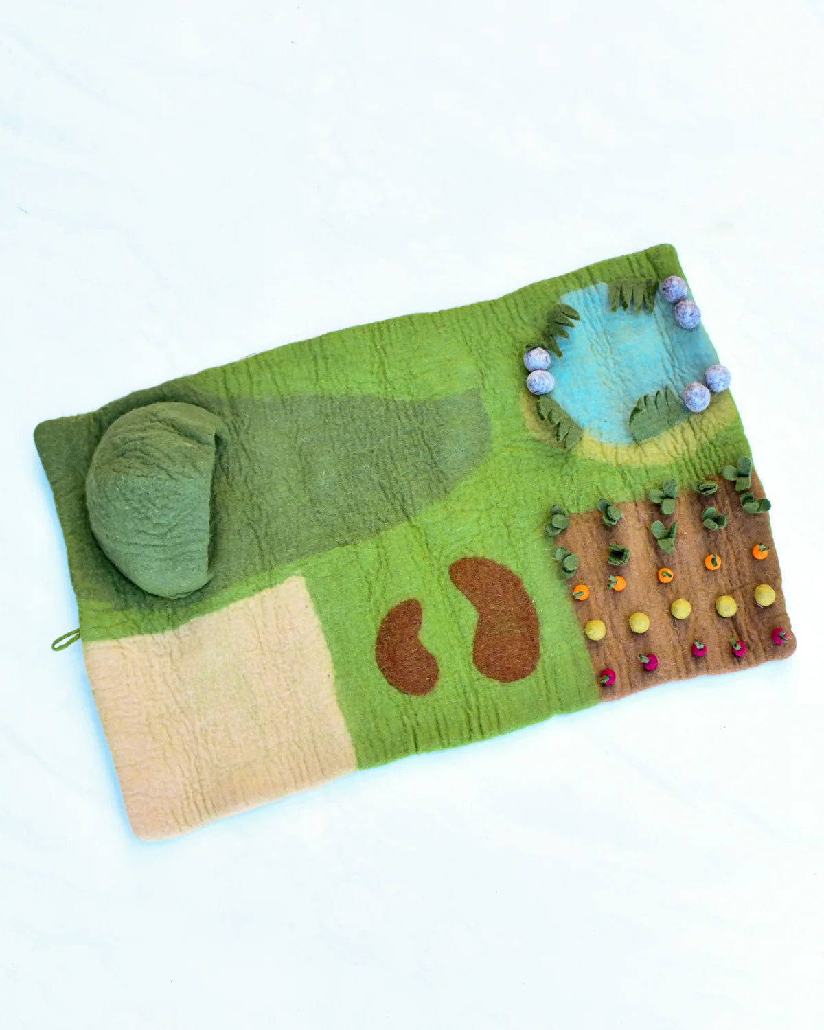 Felted landscape with green grass, brown path, and blue sky on a white background