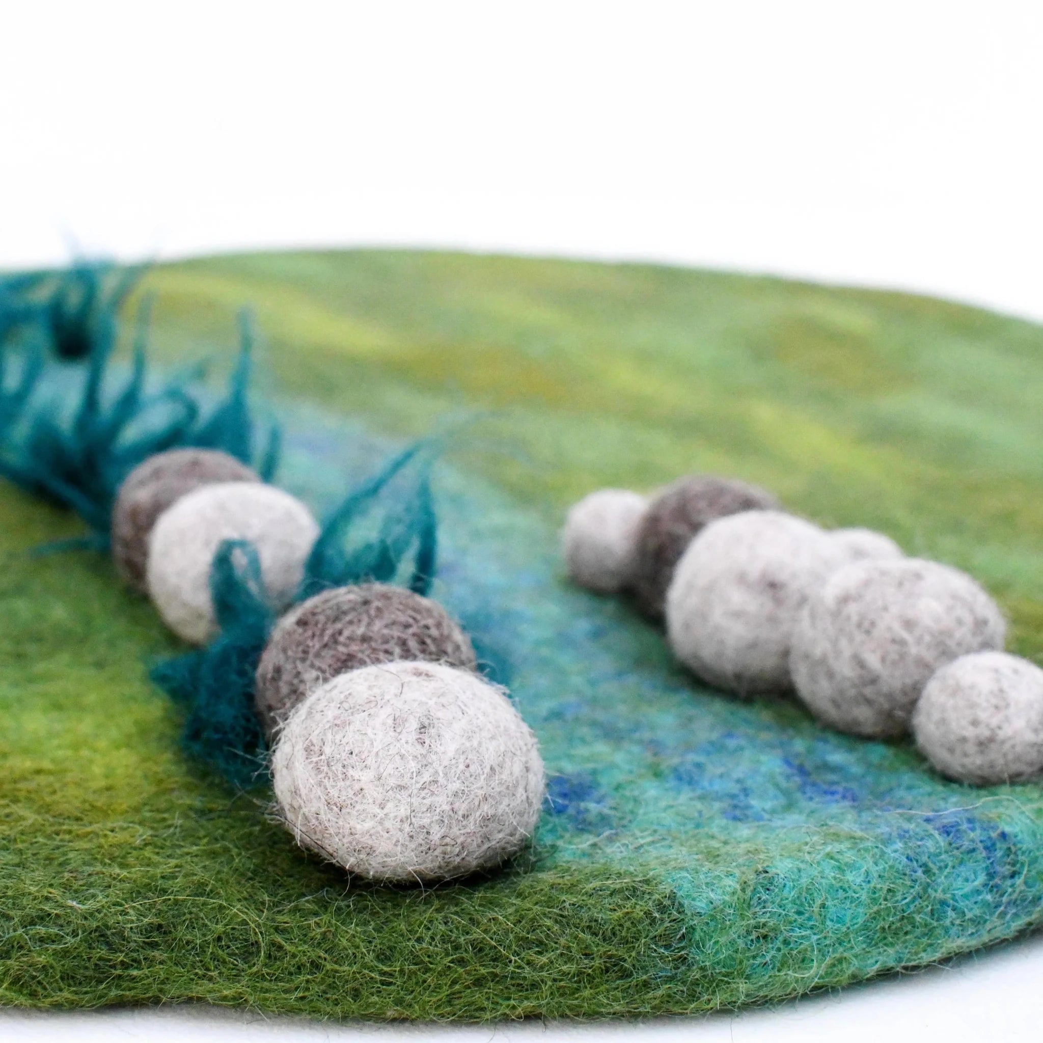 Felted balls on a textured green surface