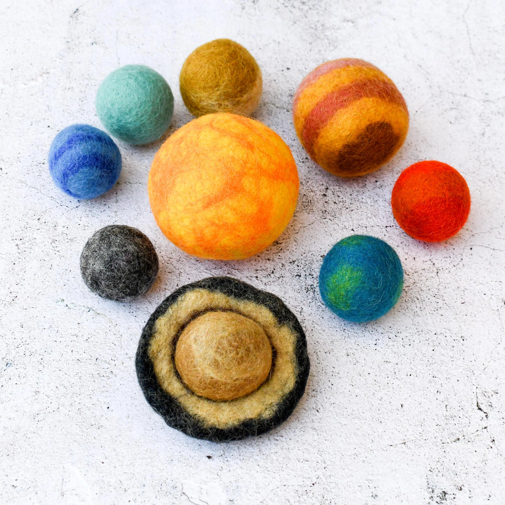 Colorful felted balls arranged on a textured surface