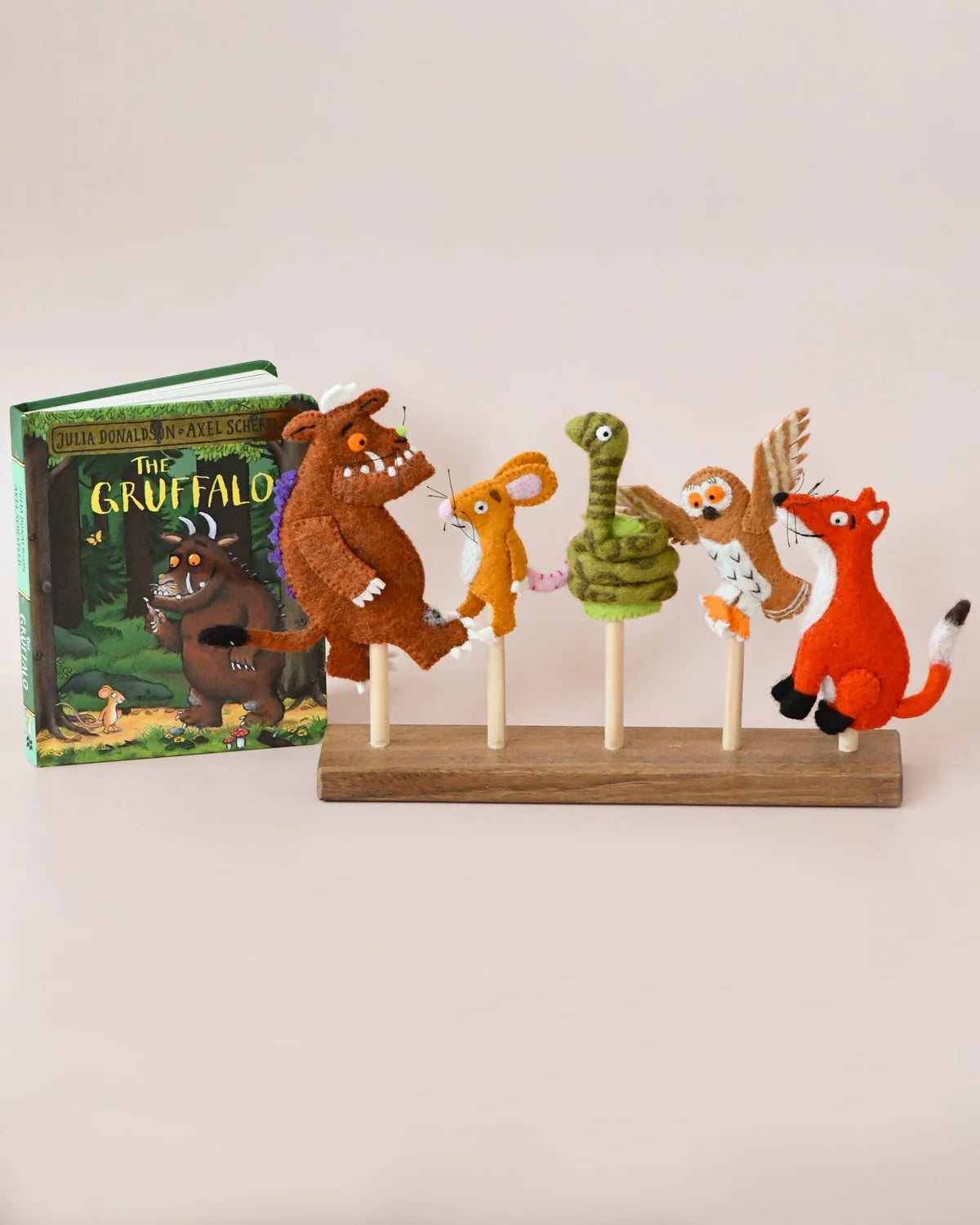 Set of Gruffalo finger puppets on a stand with a book titled 'The Gruffalo' in the background.