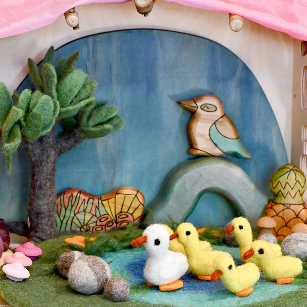 Felt craft scene with ducks, a bird, and trees on a fabric background
