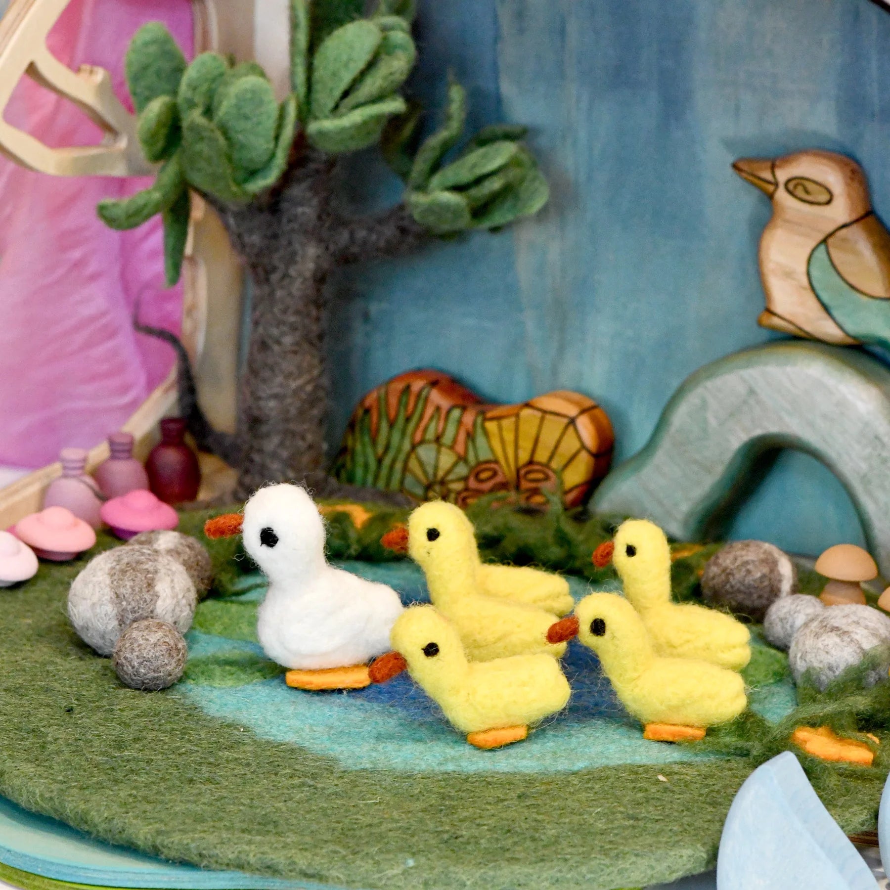 Felt ducks and a tree in a colorful felt landscape