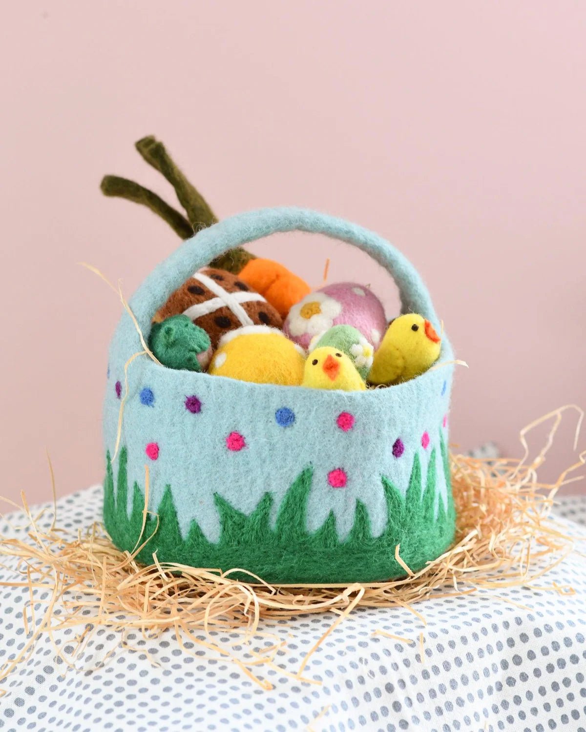 Felt Easter basket with colorful eggs and chicks on a light pink background