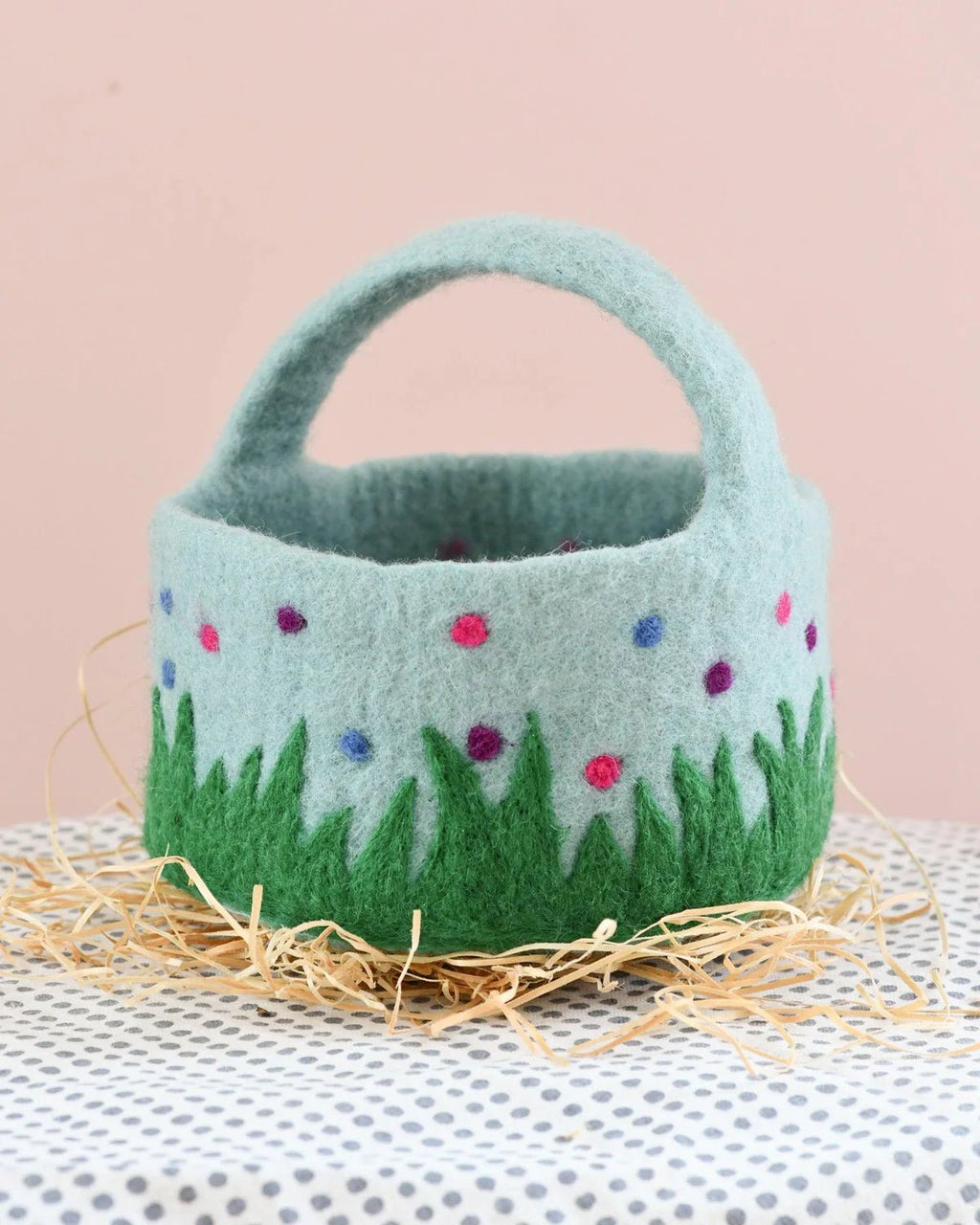 Felted basket with floral design on a neutral background