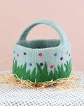 Felted basket with floral design on a neutral background