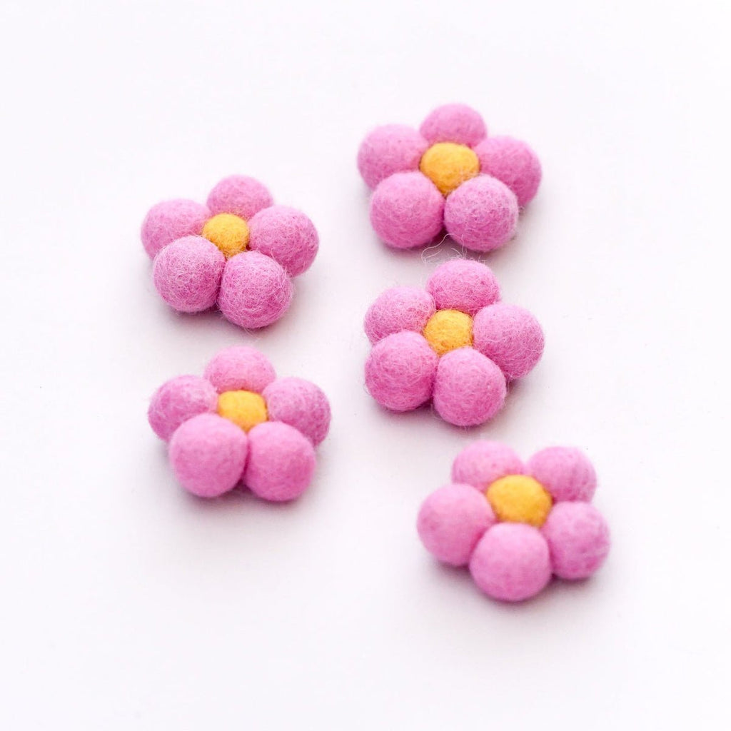 Five pink flower-shaped objects with yellow centers on a white background