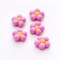Five pink flower-shaped objects with yellow centers on a white background