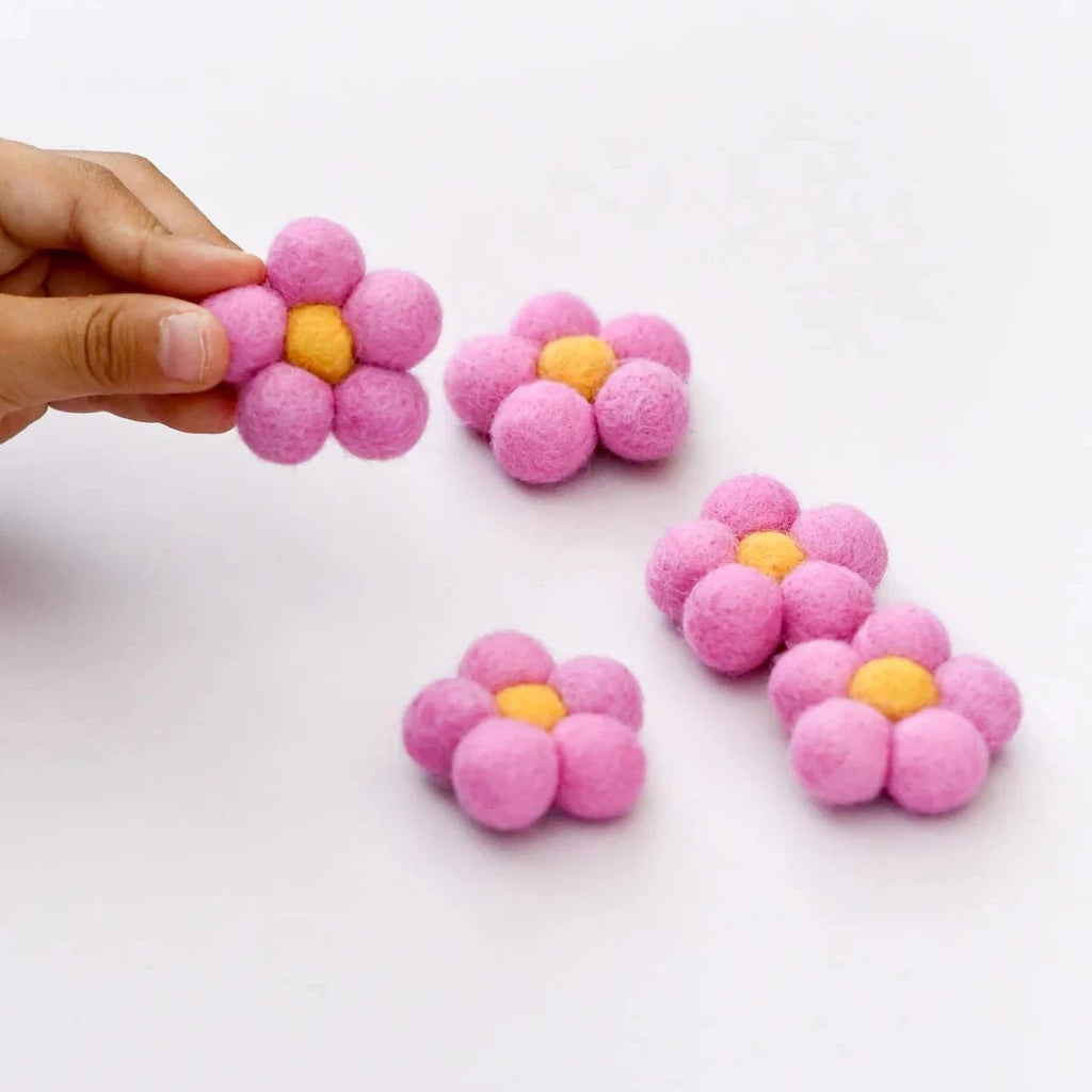 Pink flower-shaped objects with yellow centers on a white background
