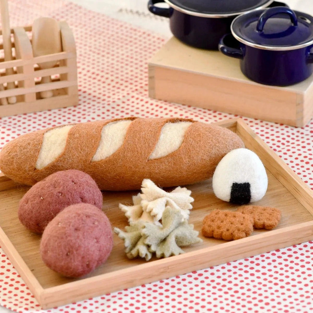 Wooden tray with bread, potatoes, and cookies on a red and white checkered tablecloth.