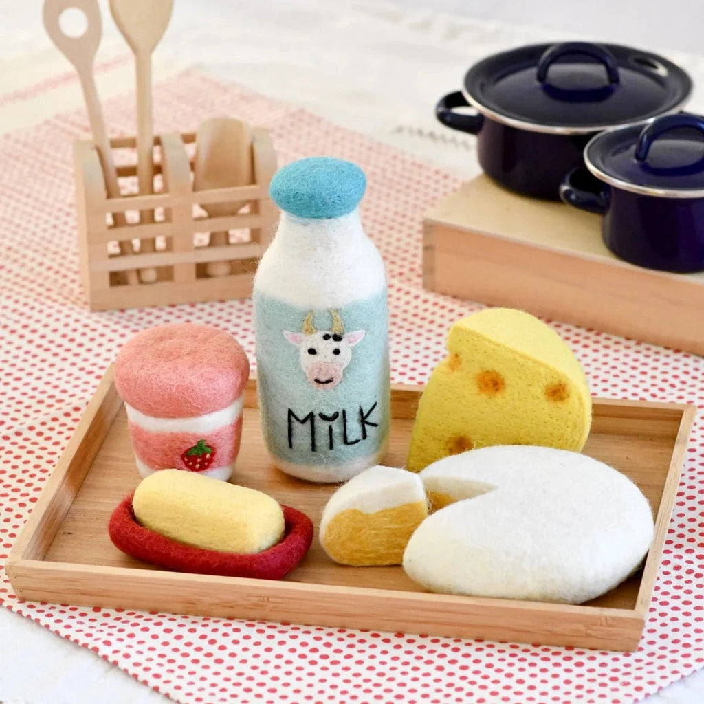 Set of toy food items including a bottle labeled 'Milk', bread, and pastries on a wooden tray.