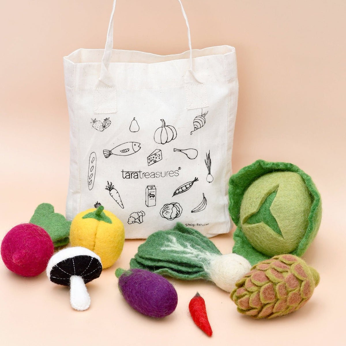 Tote bag with vegetable illustrations and felt vegetable toys on a beige background