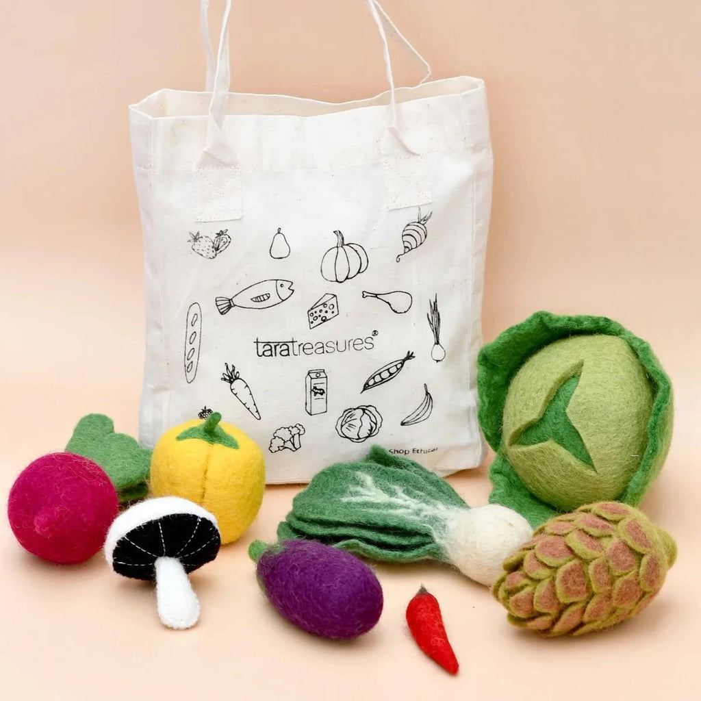 Tote bag with vegetable illustrations and felt vegetable toys on a beige background