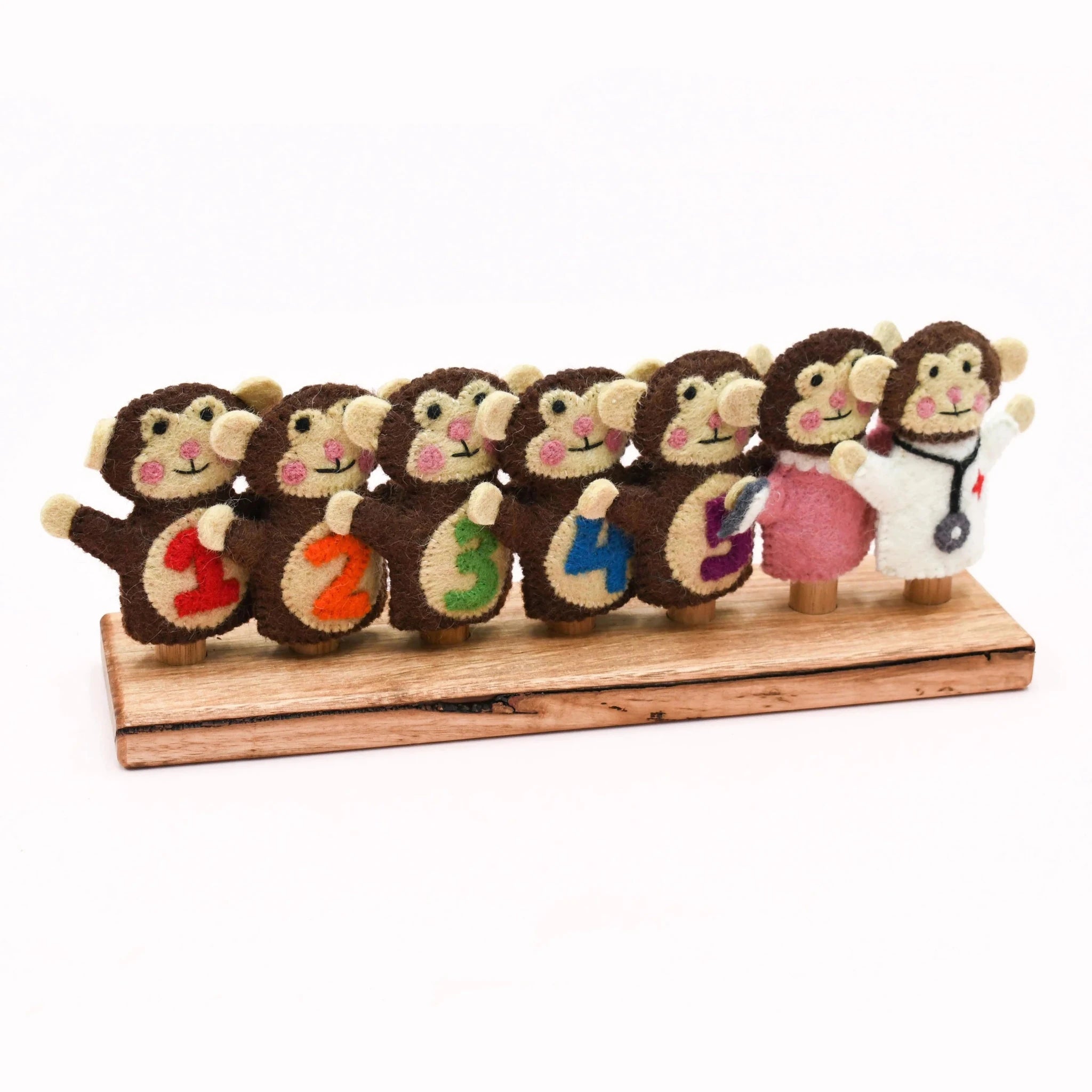 Set of toy monkeys with numbers and a doctor outfit on a wooden stand
