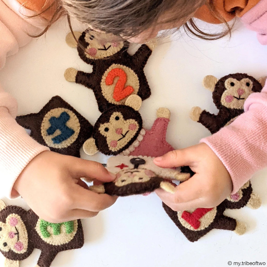 Children playing with monkey-shaped toys on a light background