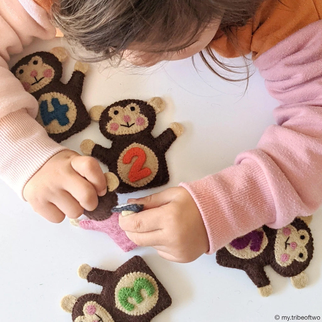 Children playing with monkey toys on a white surface