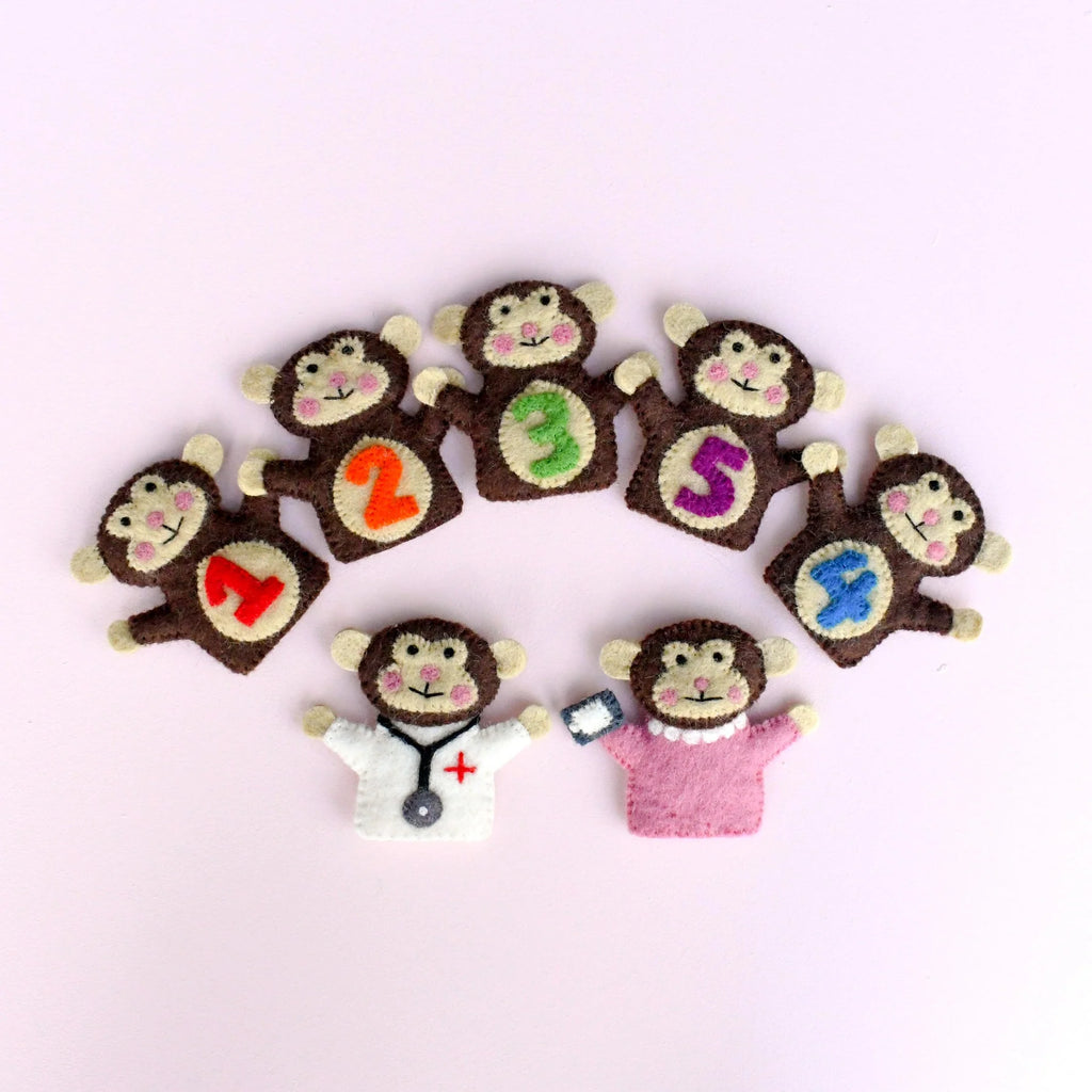 Set of monkey-shaped finger puppets with numbers and letters on a light pink background