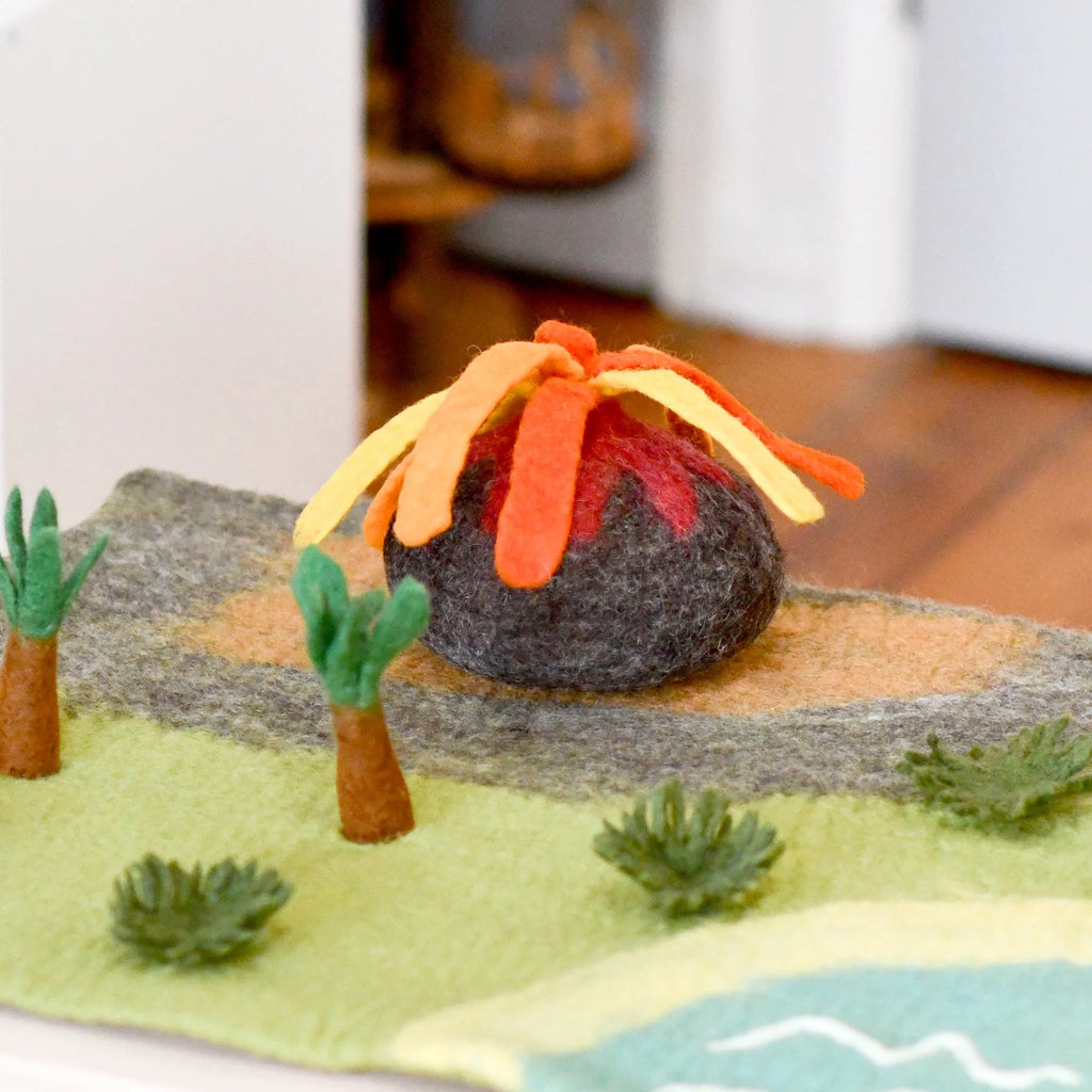 Felt volcano model with trees and landscape on a white surface