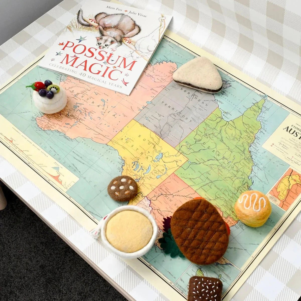 Map of Australia with cookies and a book titled 'Possum Magic' on a checkered tablecloth.