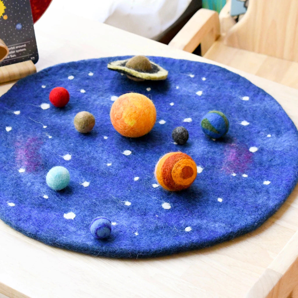 Felt solar system model on a blue felt surface with planets in various colors.