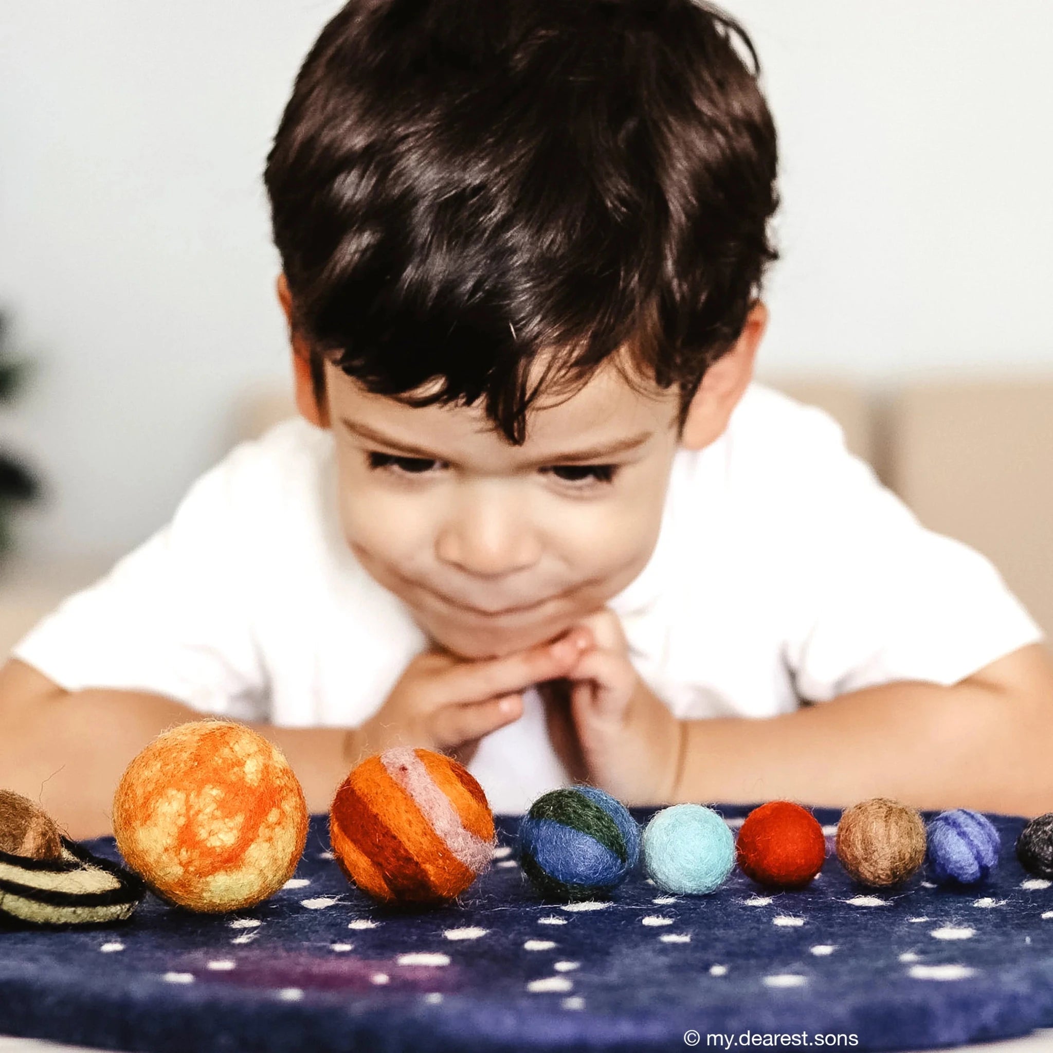 Child playing with colorful balls on a polka dot surface