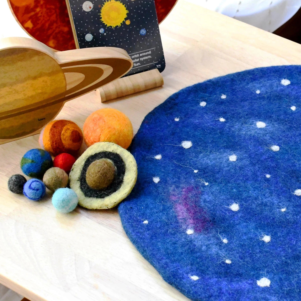 Educational solar system model with felt planets and wooden sun on a blue starry background.