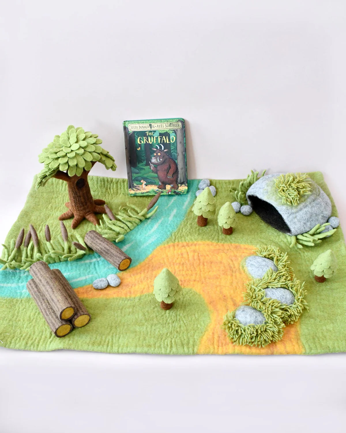 Play mat with forest scene including trees, rocks, and a book titled 'The Gruffalo'.