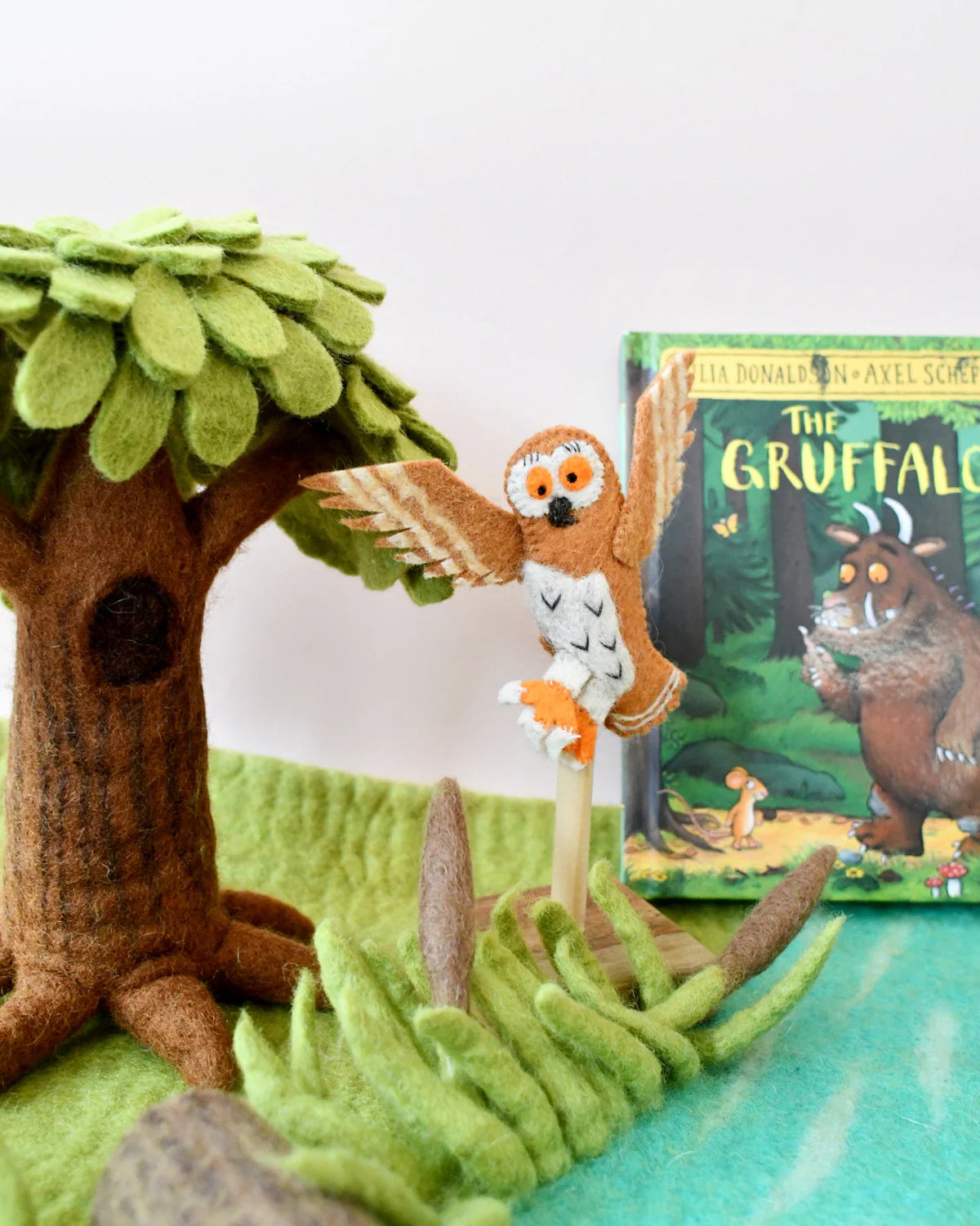 Toy owl perched on a branch with 'The Gruffalo' book in the background