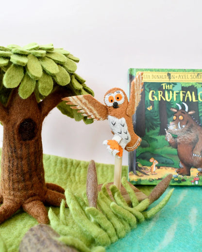 Toy owl perched on a branch with 'The Gruffalo' book in the background