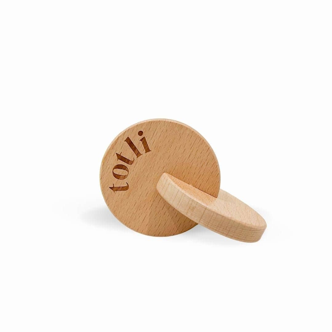 Wooden ring with 'totli' branding on a white background