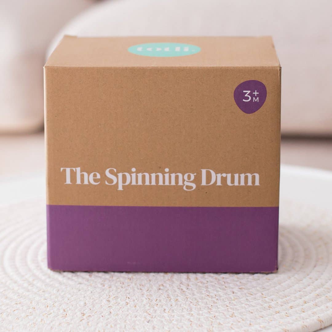 Cardboard box with 'The Spinning Drum' branding on a textured surface