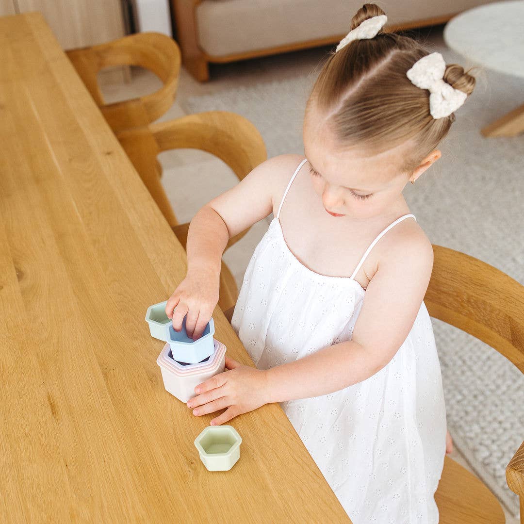 Child playing with toys at a wooden table in a home setting