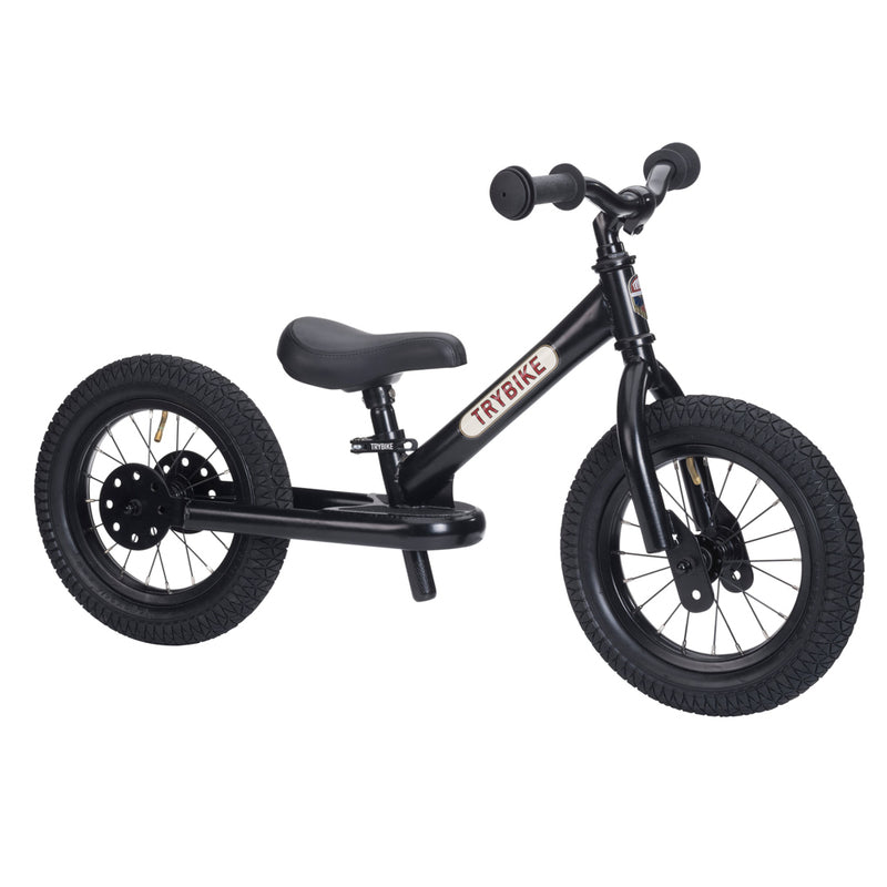 Black balance bike with visible brand name on a white background