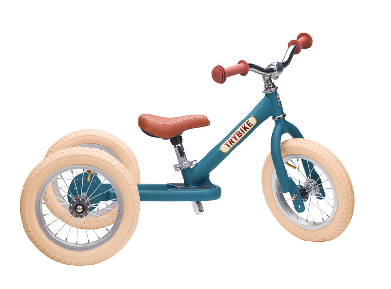 Children's balance bike with teal frame and beige tires on a white background