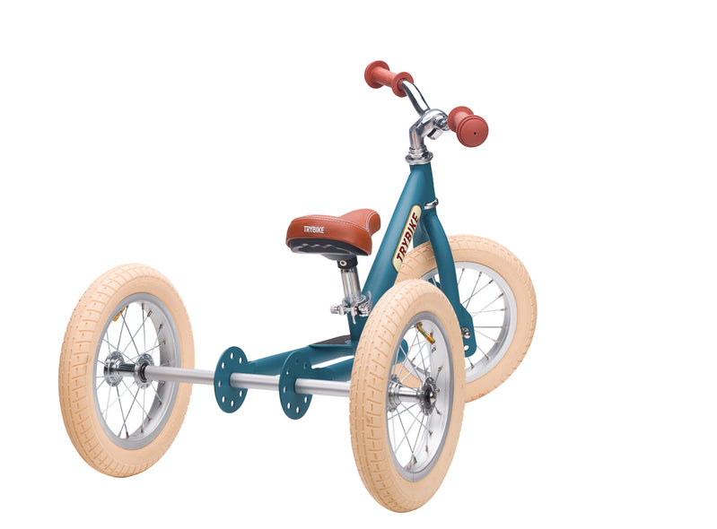 Children's tricycle with teal frame and beige wheels on a white background