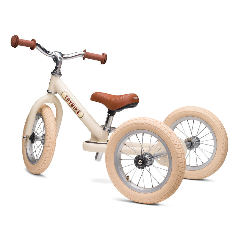 Children's balance bike with cream tires and brown seat on a white background