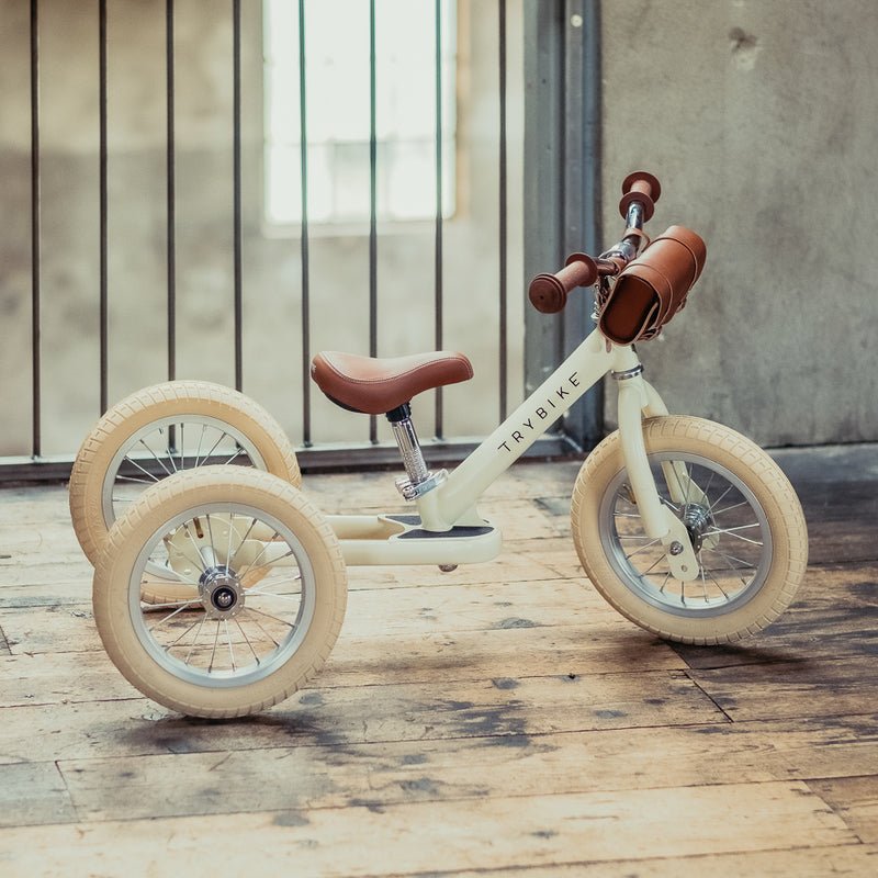 Children's tricycle on a wooden floor.