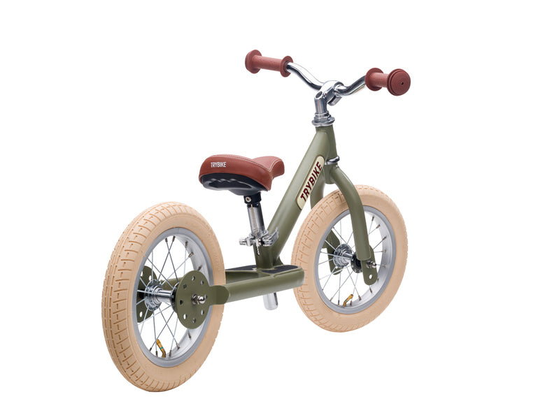 Children's balance bike with khaki frame and red handlebar grips on a white background